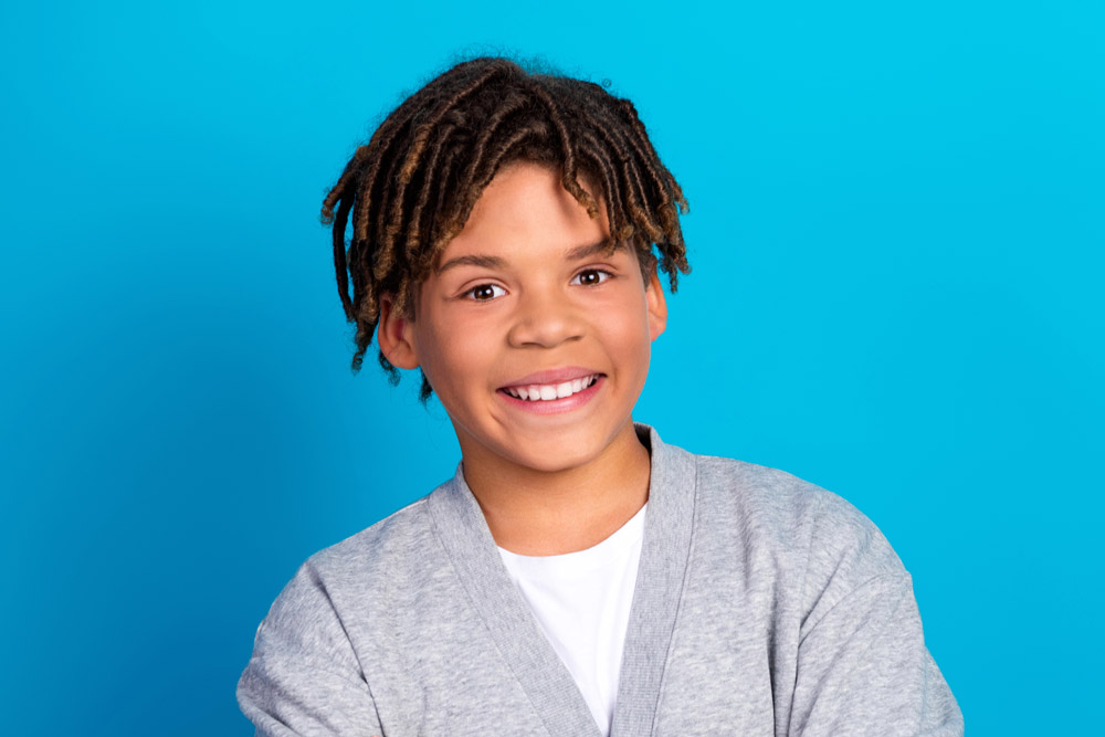 Teen boy smiling with blue background