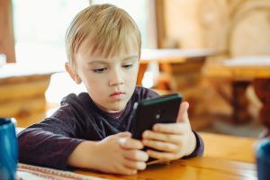 Kid playing games on smartphone.